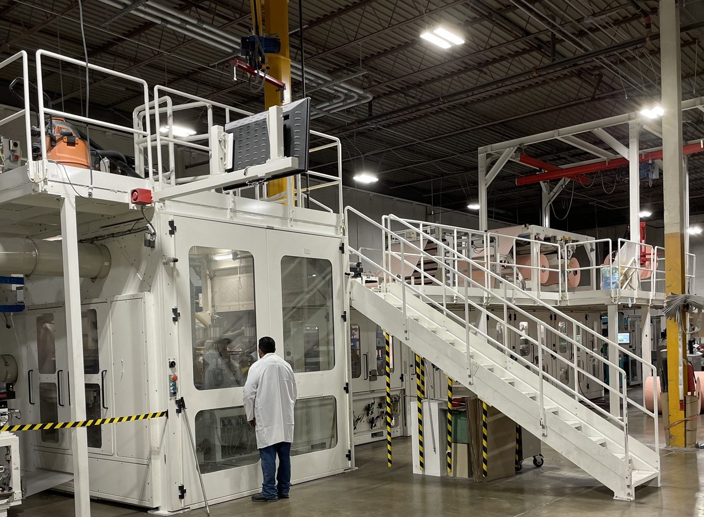 An operator checking a production line through its safety doors